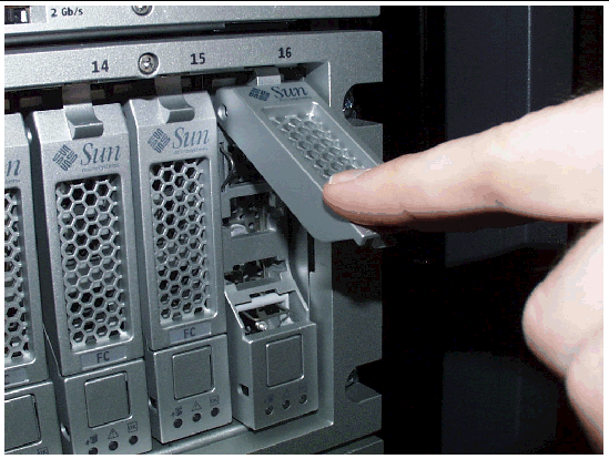 Figure shows a drive being inserted into the chassis the correct way by slowly pushing against the drive housing with a forefinger until the drive handle engages with the chassis.