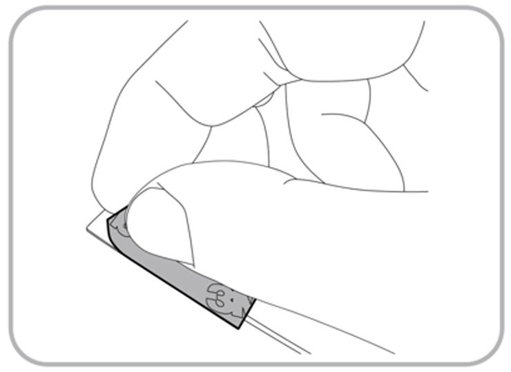 This figure shows a hand removing an adhesive strip from an antenna.