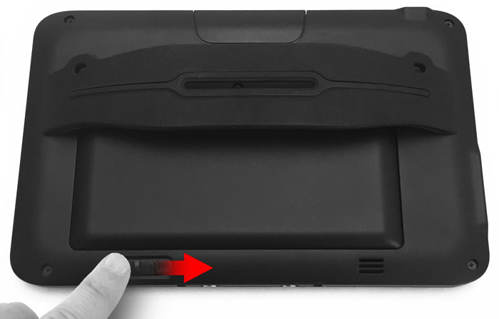 This figure depicts sliding the battery latch on the rear of the tablet.