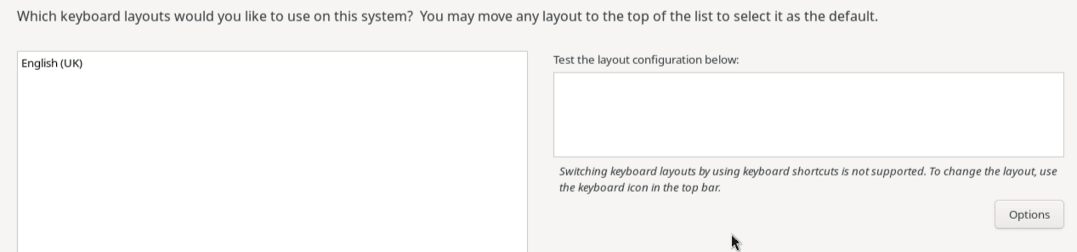 この部分的な図は、キーボード・レイアウト画面上のオプションを示しています。 左端のペインは、デフォルトのキーボード・レイアウトである英語(US)を含む領域です。 ペインの下部にあるコントロール・ボタンを使用すると、キーボード配列の追加と削除、およびリストでの順序の変更を行うことができます。 ペインの右側には、キーボード・レイアウトをテストするためのテキスト・ボックスがあります。 このテキスト・ボックスの下には、キーボード・ショートカットを使用したキーボード・レイアウトの切替えが不可能であるという警告があり、その下にはレイアウト切替えを構成するための「オプション」ボタンがあります。 