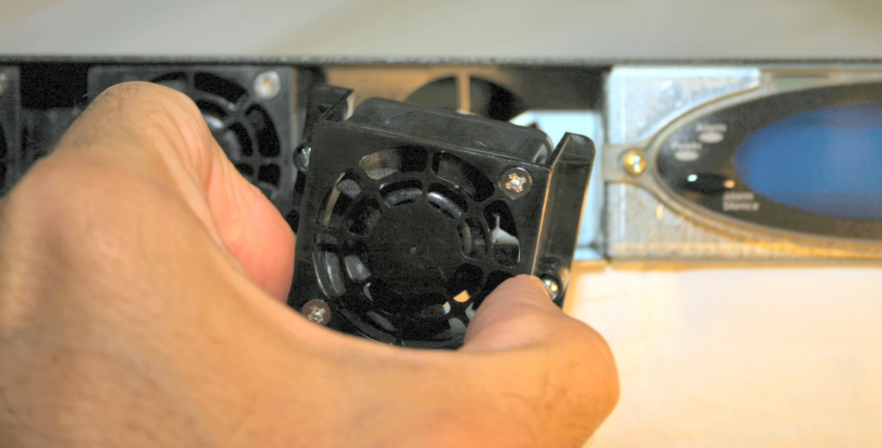 This picture shows someone inserting the fan into the chassis slot.