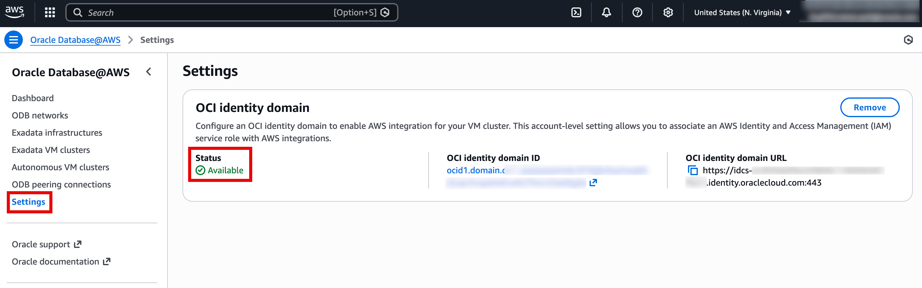 The screenshot shows the Oracle Database@AWS → Settings page in the AWS console, focused on configuring an OCI identity domain for integrations. The Status is highlighted as Available, indicating the identity domain connection is set up and active. It also displays the OCI identity domain ID and the OCI identity domain URL, which are used to enable AWS integrations (like associating IAM service roles) for VM clusters. A Remove button is available to detach this identity domain configuration from the account.